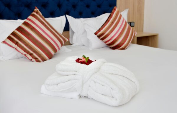 Cozy hotel room featuring plush pillows and neatly folded towels.